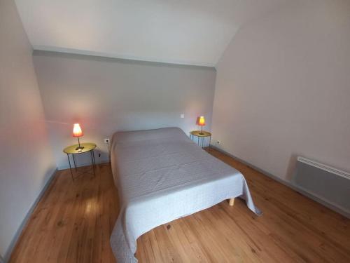 a bedroom with a bed and two lamps on two tables at Maison avec jardin in Adé