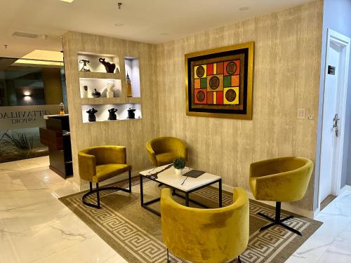 a waiting room with yellow chairs and a table at 2 Dormitorios Edificio Zetta Village Airport in Colonia Mariano Roque Alonso