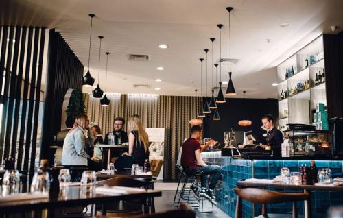 a group of people sitting at a bar in a restaurant at Mantra Albury in Albury
