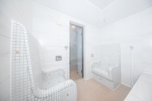 un bagno bianco con due lavandini e uno specchio di Hachikan a Kyoto