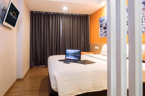 a hotel room with a laptop on a bed at The Hills Batam in Nagoya