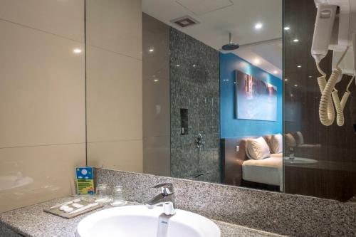 a bathroom with a sink and a mirror at The Hills Batam in Nagoya