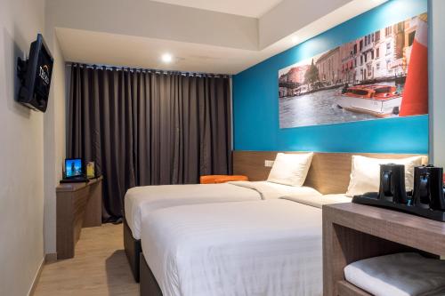 a hotel room with a bed and a blue wall at The Hills Batam in Nagoya