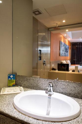 a bathroom counter with a sink and a large mirror at The Hills Batam in Nagoya