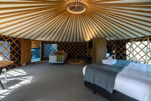 a bedroom with a bed and a large ceiling at The Yurts at Obsidian View in Putiki