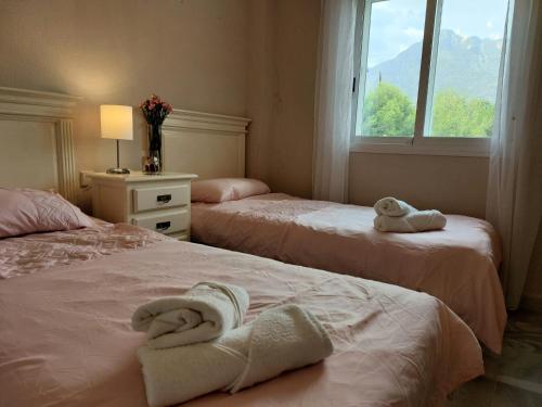 2 Betten mit Handtüchern in einem Schlafzimmer in der Unterkunft La Palmera - Amazing apartment with excellent location & views in Marbella