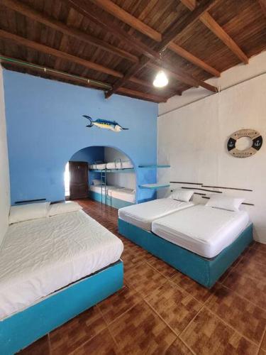 1 dormitorio con 2 camas y pared azul en fantástica habitación frente al mar 103, en San Silvestre