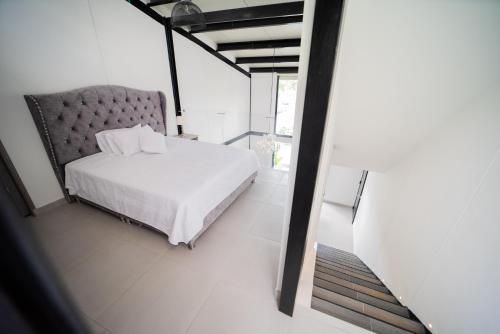 1 dormitorio con 1 cama blanca y 1 silla en hermosa cabaña multinivel para pareja, 