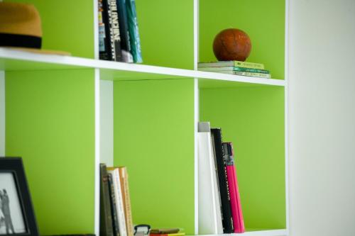 a book shelf with books and a basketball on it at דירות גני תערוכה - TLV university apartments near Expo by Sea N' Rent in Tel Aviv