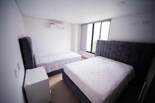 - une petite chambre avec 2 lits et une télévision dans l'établissement Hermosa habitación 4 personas, à Rozo