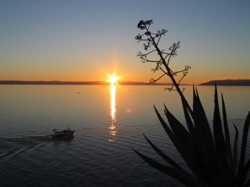 a boat on a lake with the sun setting at Apartment Bibo in Grubine