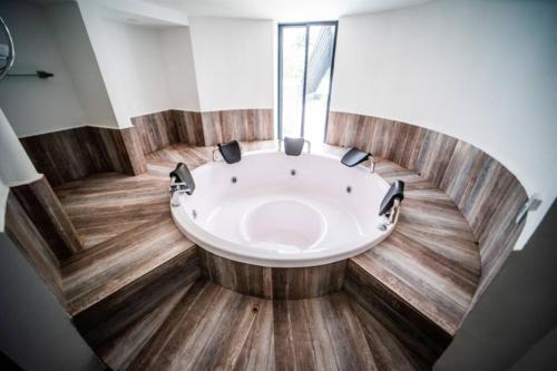 uma grande banheira num quarto com piso de madeira em luxury suite presidencial 