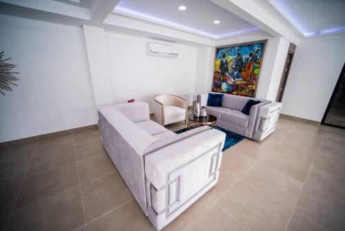 a living room with two white couches and a painting at luxury suite presidencial 