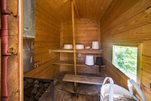 a wooden cabin with shelves and a window in it at Lammashaan tupa lammen rannassa in Ruovesi