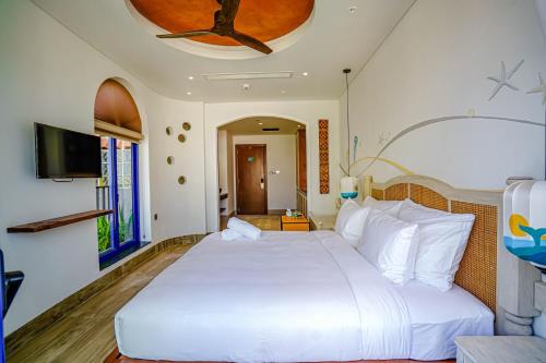 a bedroom with a large white bed with a ceiling at Seahorse Signature Danang Hotel by Haviland in Da Nang
