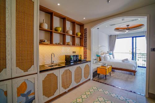 a kitchen with a sink and a bed in a room at Seahorse Signature Danang Hotel by Haviland in Da Nang