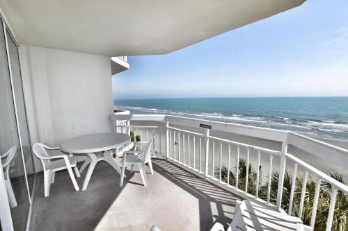 uma varanda com uma mesa e cadeiras e o oceano em 0404 Waters Edge Resort condo em Myrtle Beach