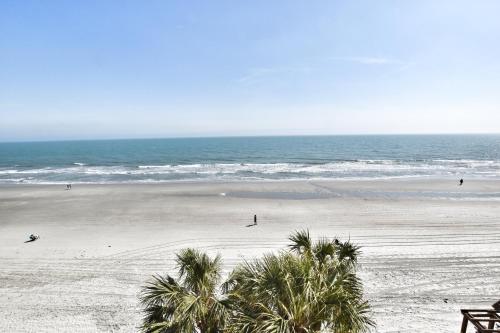 uma praia com palmeiras e o oceano em 0404 Waters Edge Resort condo em Myrtle Beach