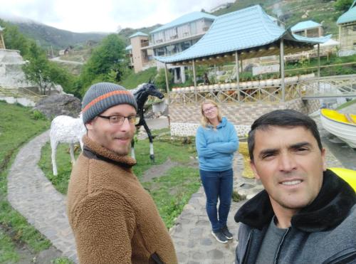 two men are standing in front of a horse at Zaur Guest hause in Xınalıq