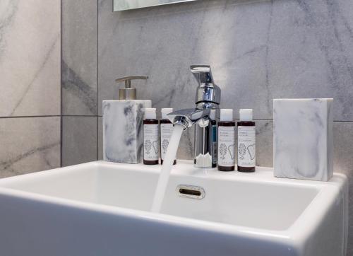 a bathroom sink with toothbrushes and soap on it at Villa Zeta in Chrissi Akti