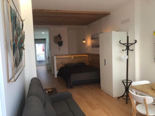 ein Wohnzimmer mit einem Sofa und einem Bett in der Unterkunft Casa de São Roque in São Roque