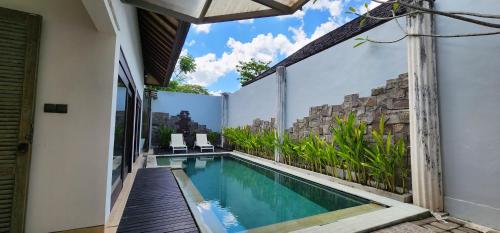 a swimming pool on the side of a building at Zoe Villa Canggu Bali in Canggu