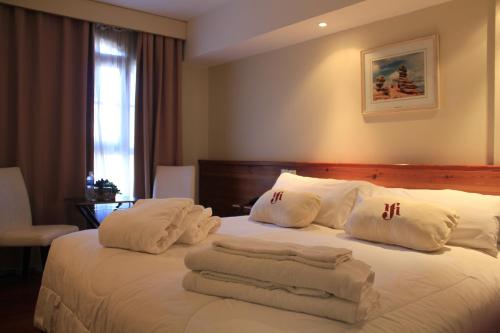 Una habitación de hotel con una cama con toallas. en San Martin Hotel y Spa en San Rafael