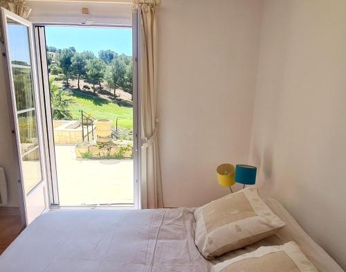 ein Schlafzimmer mit einem Bett und einem großen Fenster in der Unterkunft VILLA DANS CADRE D'EXCEPTION - GOLF, PISCINE ET TENNIS PRIVE in Saint-Cyr-sur-Mer
