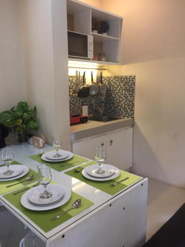a kitchen with a table with plates and glasses on it at House at Taman Dayu in Pasuruan