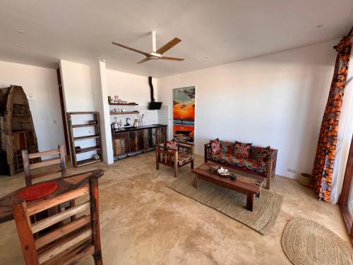 a living room with two chairs and a ceiling fan at The View of Zanzibar in Michamvi