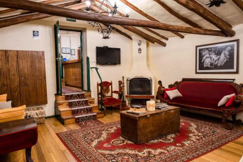 uma sala de estar com um sofá e uma televisão em Hostal Corihuasi em Cusco