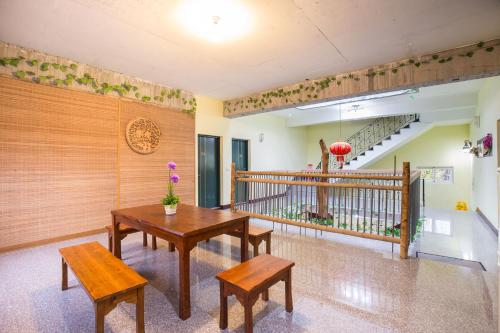 a room with two tables and benches and a staircase at Three Maybe B&B in Lugu