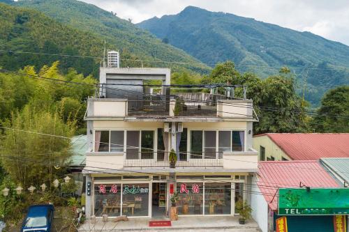 a building with a balcony on top of it at Three Maybe B&B in Lugu