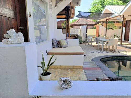 a patio with a couch next to a pool at Katara Gili, Boutique Rooms and Bungalows in Gili Trawangan