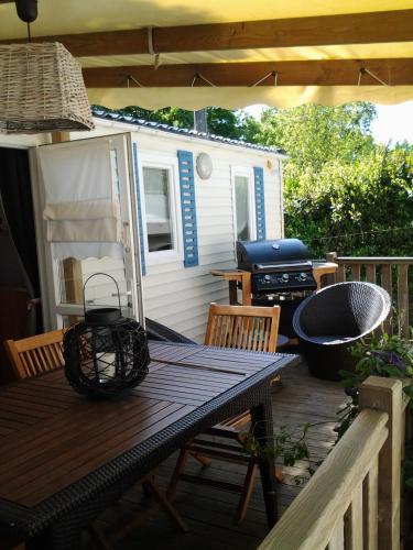 - une table de pique-nique sur le pont d'une petite maison dans l'établissement LOCATION BUNGALOW, à Les Sables Vignier