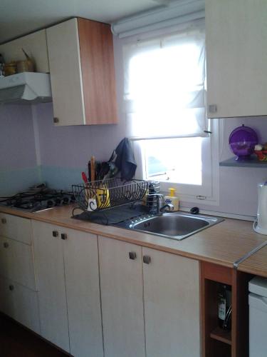 un comptoir de cuisine avec un évier et une fenêtre dans l'établissement LOCATION BUNGALOW, à Les Sables Vignier