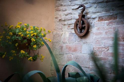 a brick wall with a metal object next to a plant at Relais B&B Corte Dei Turchi in Longiano