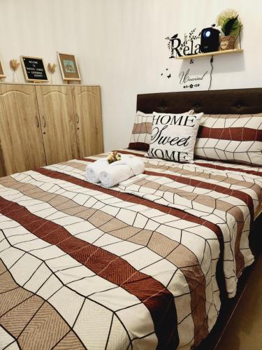 1 dormitorio con 1 cama grande y toallas. en Marco's Lounge 1 en Imus