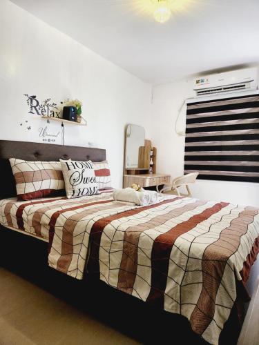 um quarto com uma cama com um cobertor xadrez em Marco's Lounge 1 em Imus