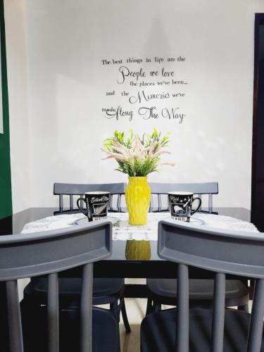 un tavolo con due sedie e un vaso con fiori di Marco's Lounge 1 a Imus