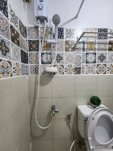 uma casa de banho com um chuveiro e um WC. em Marco's Lounge 1 em Imus