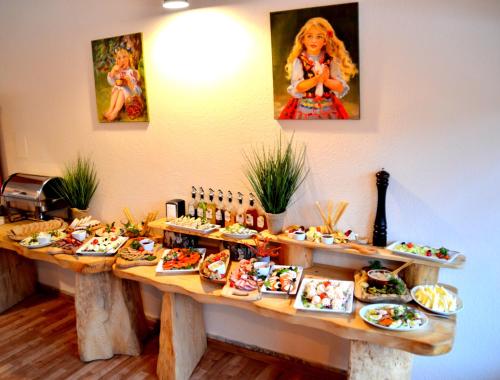 a table filled with plates of food in a restaurant at Ośrodek Perełka Bieszczady in Cisna