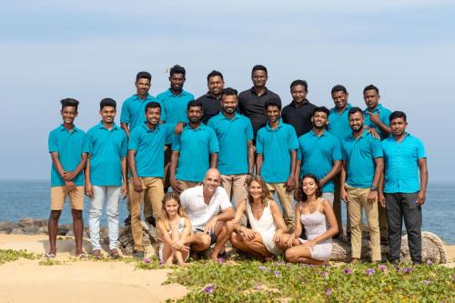 a group of people posing for a picture on the beach at Elements Beach & Nature Resort in Kalpitiya