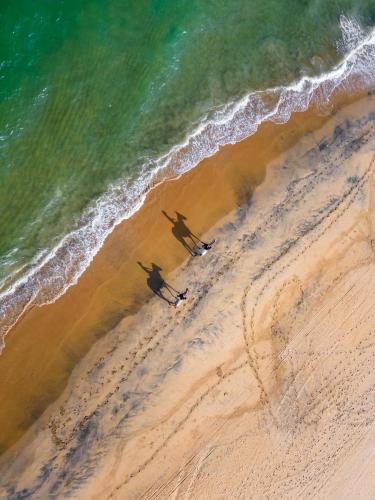 two surfers walking on the beach near the ocean at Elements Beach & Nature Resort in Kalpitiya