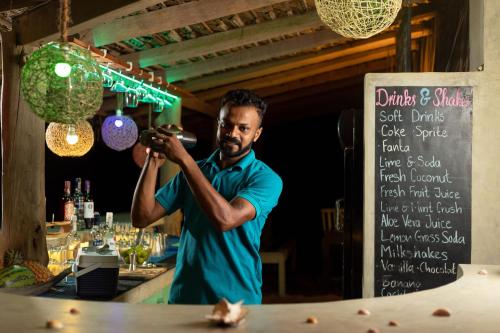a man taking a picture of a bartender at a bar at Elements Beach & Nature Resort in Kalpitiya