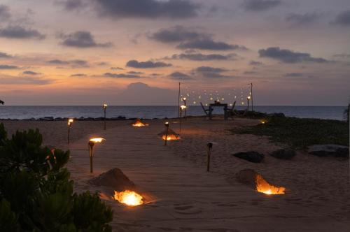 a beach with a table and lights on the beach at Elements Beach & Nature Resort in Kalpitiya