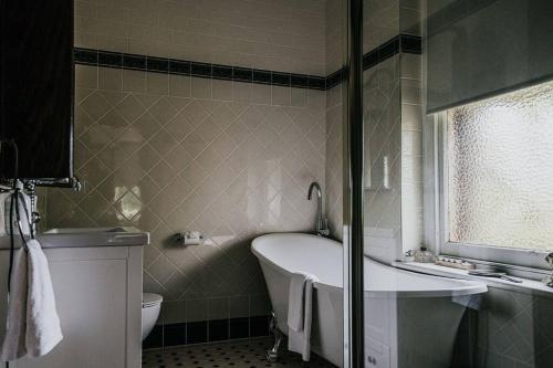 y baño con bañera, aseo y lavamanos. en Green Gables King Suite en Castlemaine