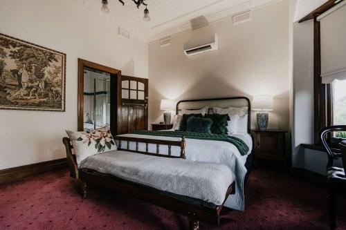 1 dormitorio con cama y banco. en Green Gables King Suite en Castlemaine