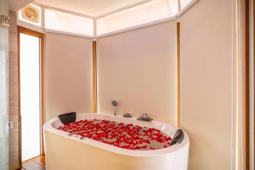 a bath tub filled with lots of red roses at amã Stays & Trails - Werifesteria, Coonoor in Coonoor