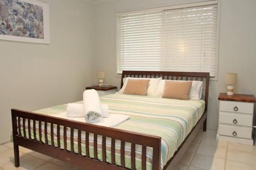 een slaapkamer met een groot bed met 2 nachtkastjes bij KIAMA AMITY POINT in Amity Point
